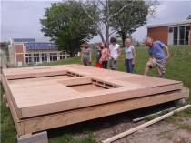 Students and volunteers raise the walls on Heather Caldwell's tiny house. / KTVO's Kate Allt